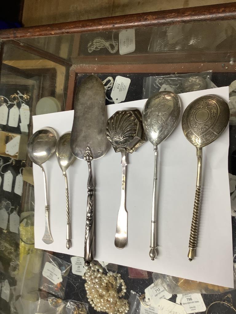 A late 19th century Russian 84 zolotnik tea strainer, a Russian cake slice and sugar sifter and a group of other Russian flatware including enamelled teaspoons